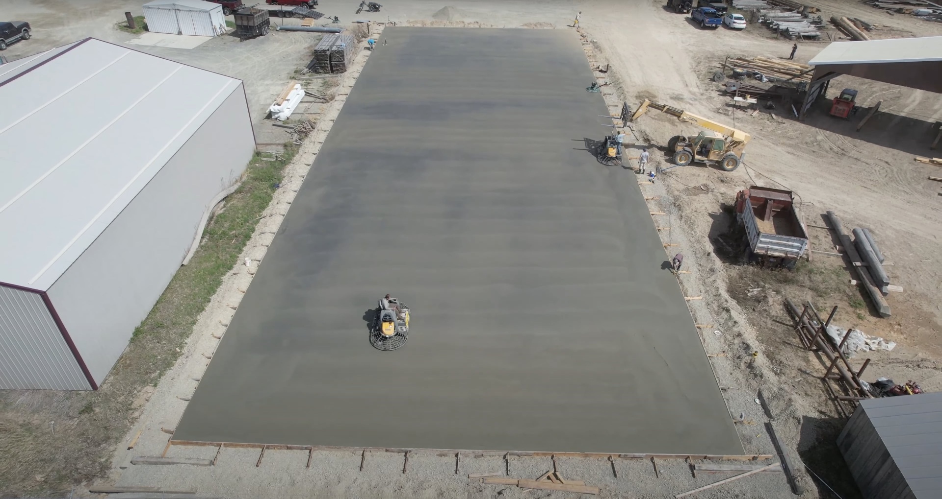 Commercial Concrete Slab Installation Large commercial concrete slab installation with heavy equipment and professional crew
